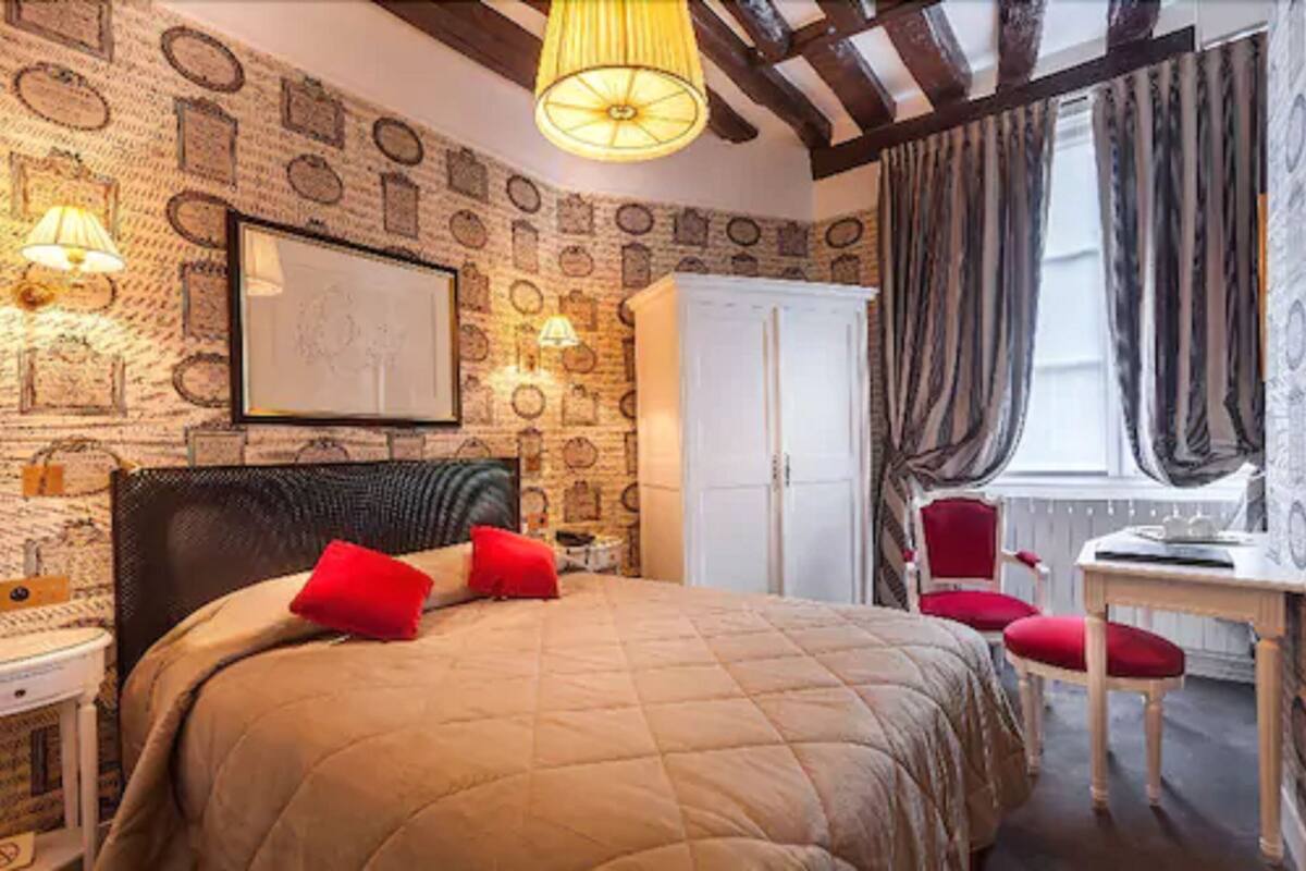 A bedroom with a bed, a desk, and a wardrobe.