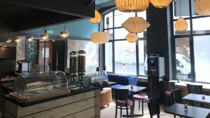 A modern cafe interior with a counter, seating area, and large windows. -  Hotelo Lyon Ainay (Lyon)