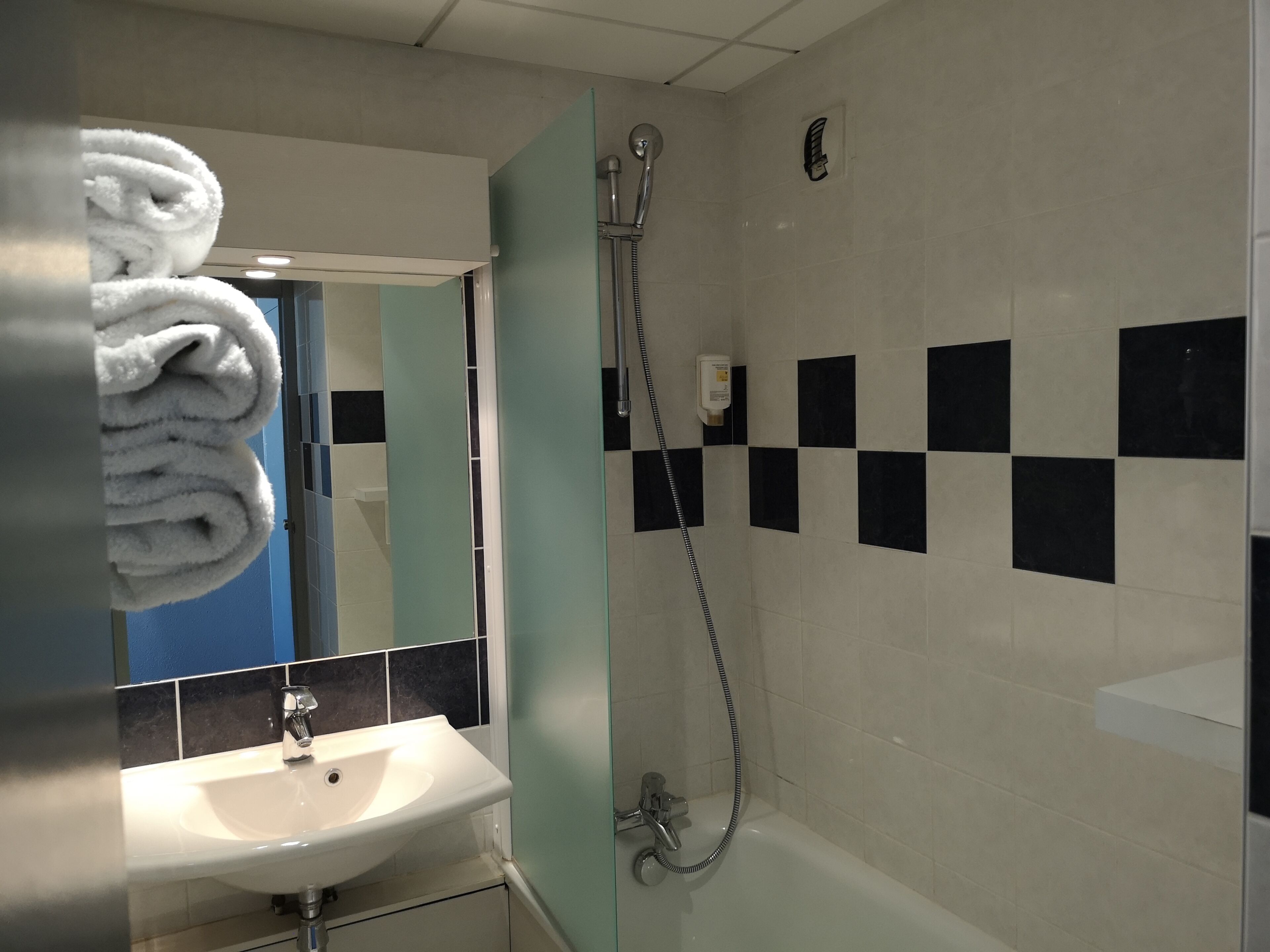 Une salle de bain avec un lavabo, un miroir et une douche.