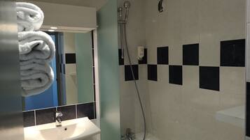 A bathroom with a sink, mirror, and shower.