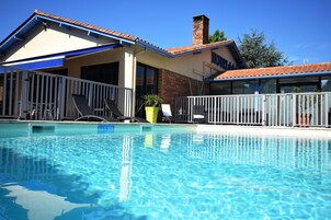 Una piscina al aire libre, sillones reclinables de piscina