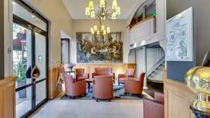 A lobby with a chandelier, seating area, artwork, and a staircase. - Grand Hotel des Gobelins (Paris)