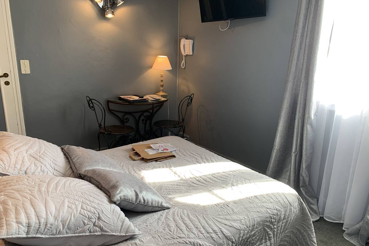 Un dormitorio con dos camas, un escritorio con lámpara y un teléfono.
