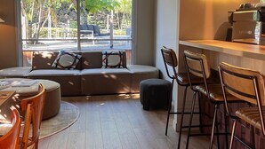 Ein modernes Hotelinterieur mit Sitzgelegenheit, Bar und einer Neonreklame mit dem Hotelnamen.