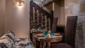 Un interior acogedor con una escalera de madera, un sofá estampado y una mesa servida con platos y vasos.