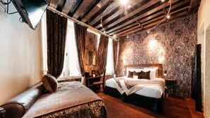 Un dormitorio con dos camas, un sofá y una pared con diseño de piedra.