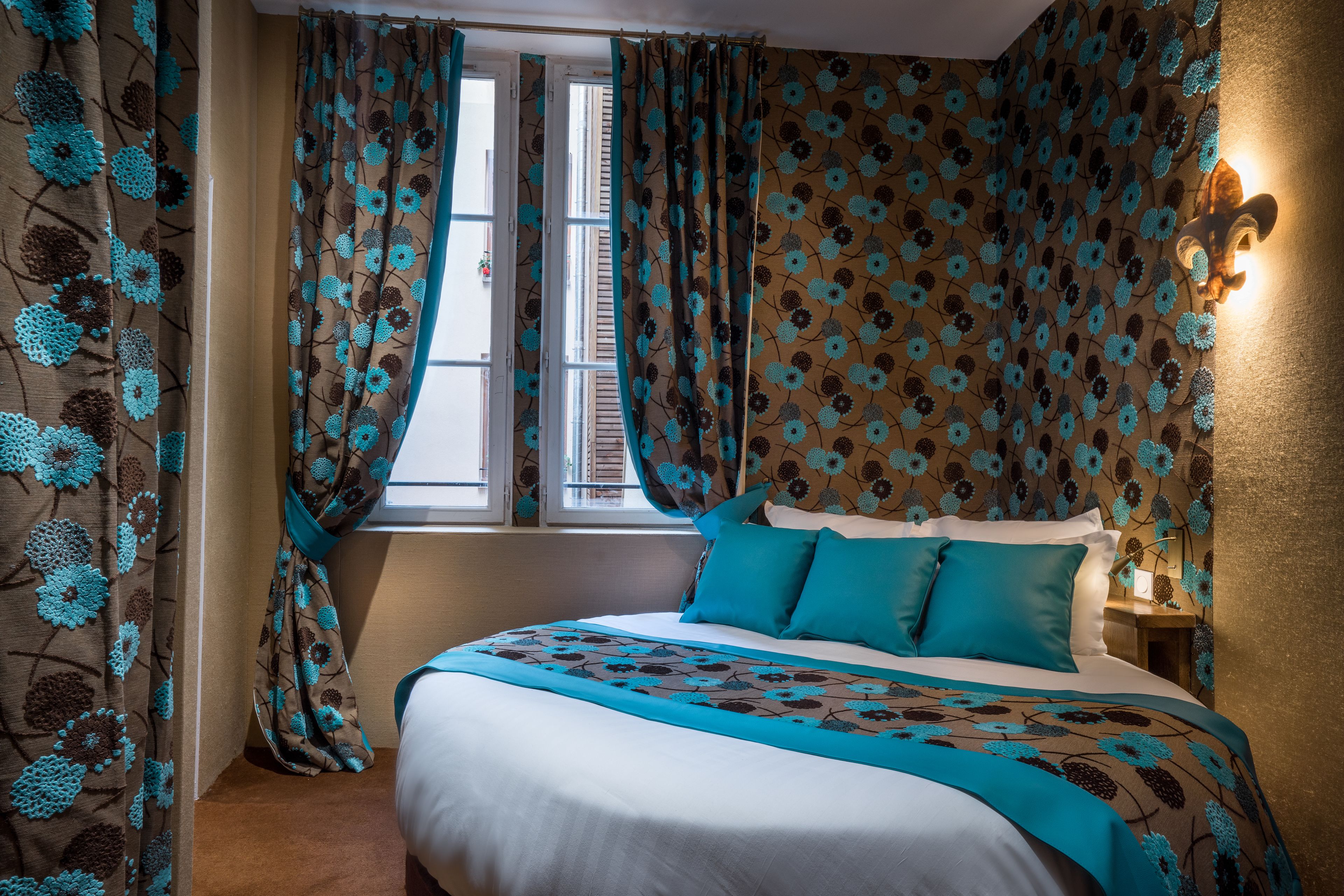 A bedroom with a large bed, curtains, and a nightstand with a lamp.