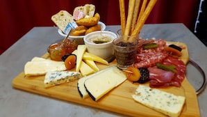 A charcuterie board with various cheeses, meats, pickles, and crackers. - Occitania Centre Toulouse Matabiau (Toulouse)