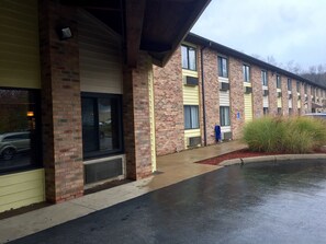 A brick building with multiple windows and a covered entrance.