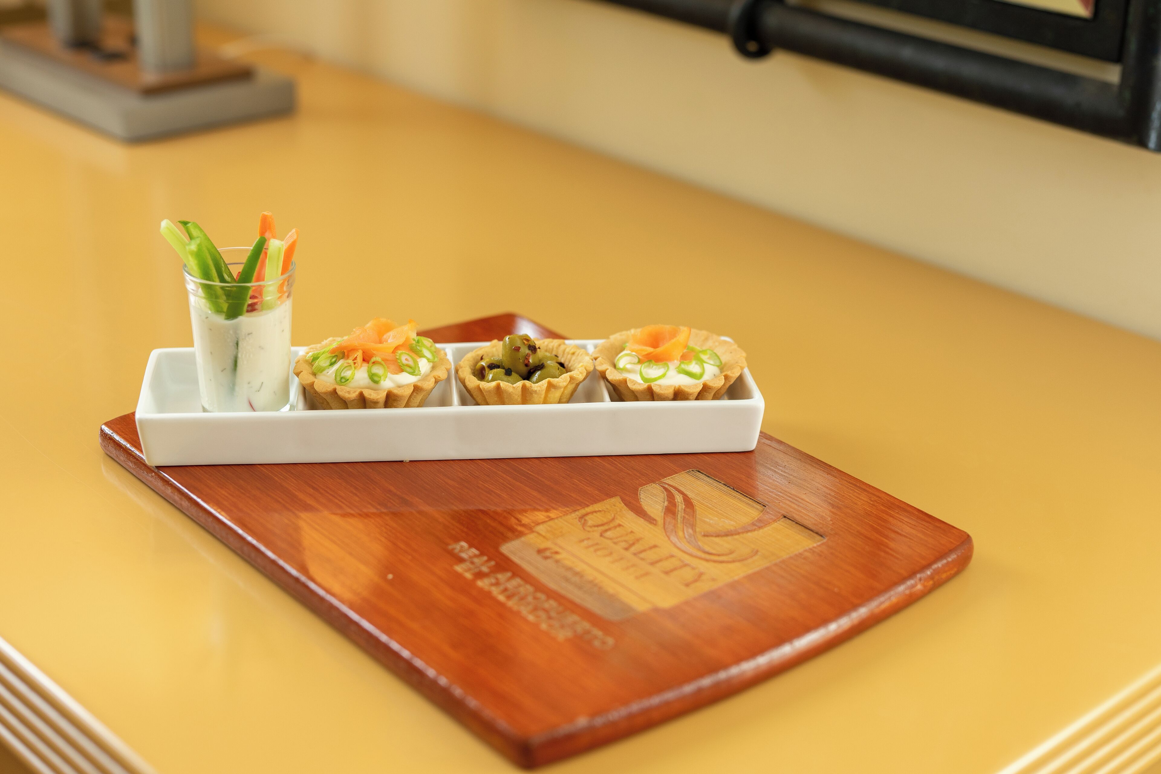 A tray with three desserts on a wooden table.