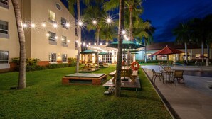 A well-lit outdoor area with picnic tables, umbrellas, and string lights. - Quality Hotel Real Aeropuerto (San Luis Talpa)