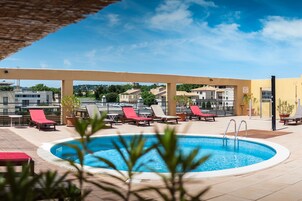 Una piscina al aire libre de temporada, sillones reclinables de piscina