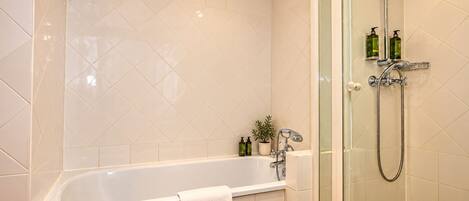A bathroom with a bathtub, a shower, and a glass-enclosed shower area.