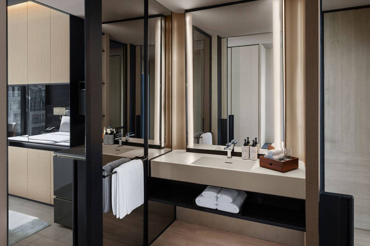 Un baño moderno con un espejo grande, dos lavamanos y un mueble de tocador con espacio de almacenamiento.