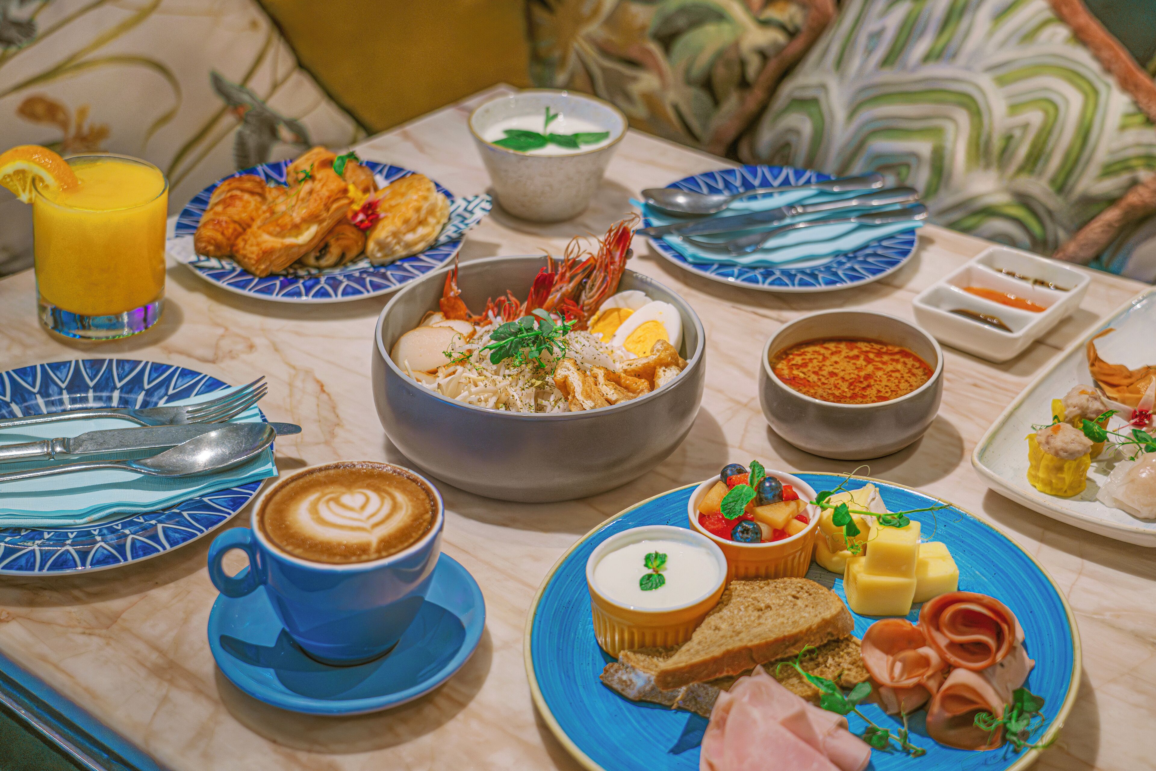 Una escena de desayuno con platos de comida, una taza de café y un bol de sopa.