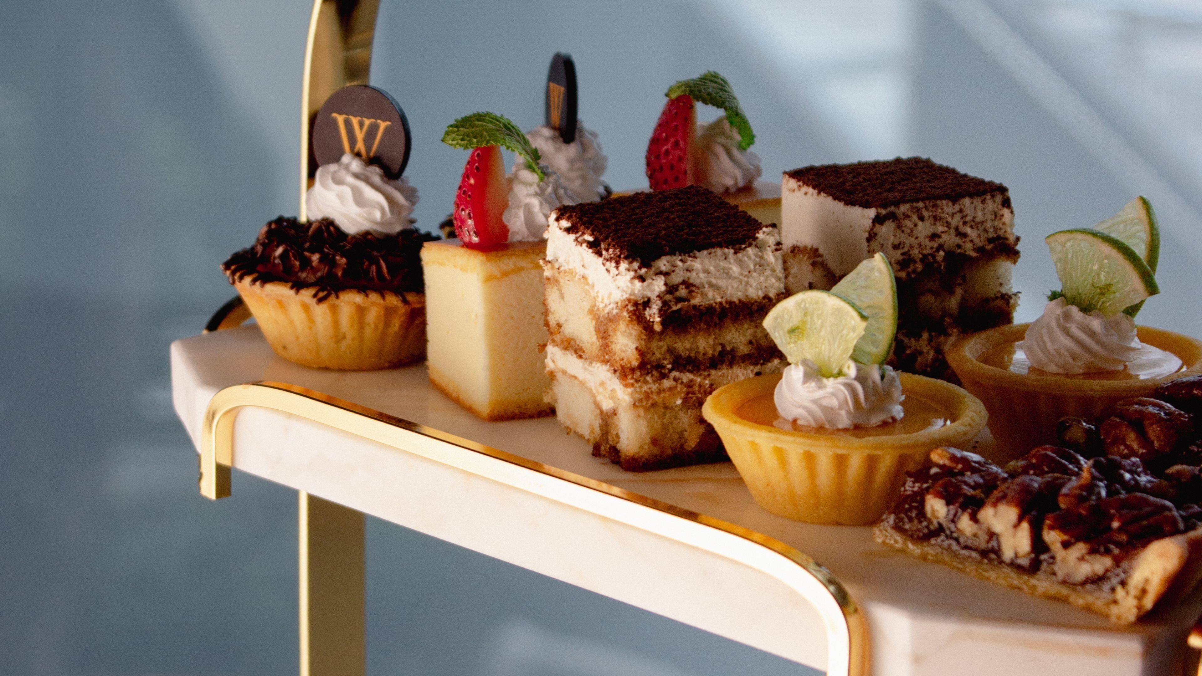 Un assortiment de desserts présentés sur un chariot de service blanc.