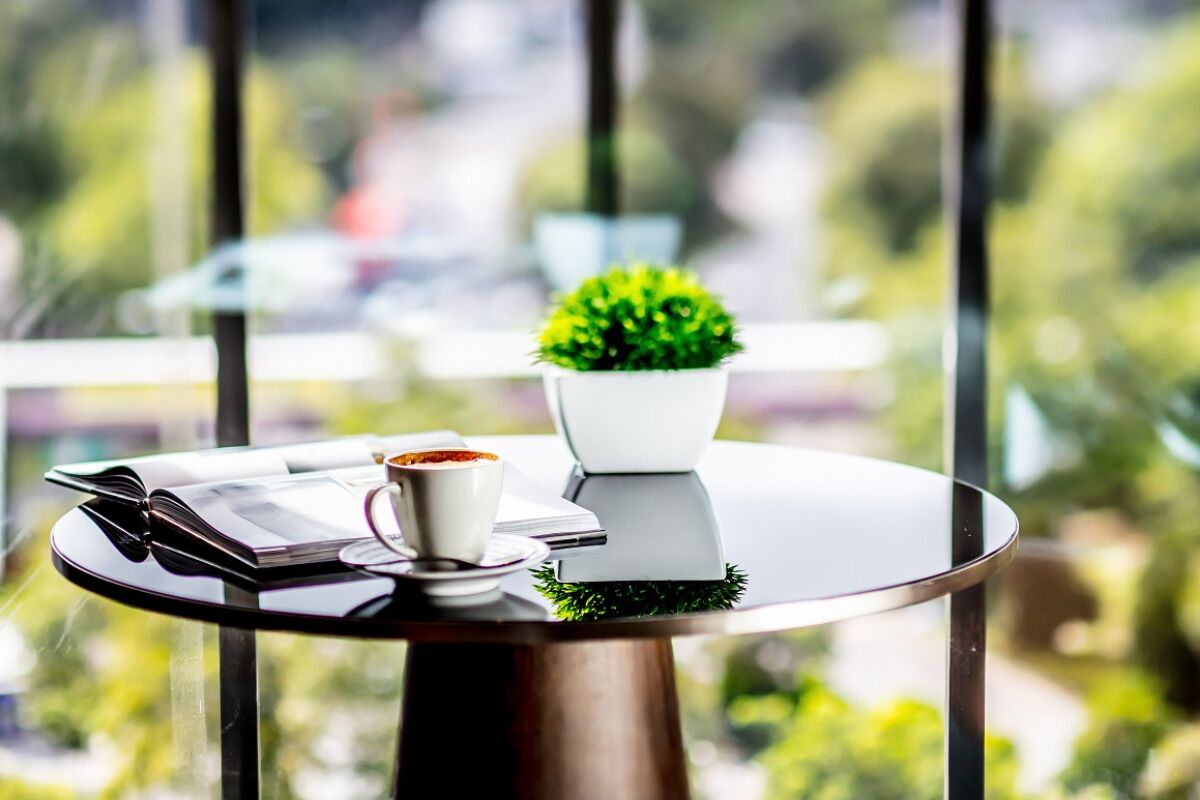A round table with a coffee cup, a book, and a small potted plant.