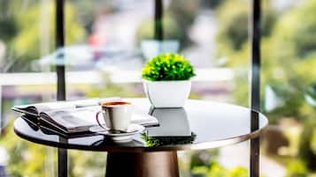 A round table with a coffee cup, a book, and a small potted plant.