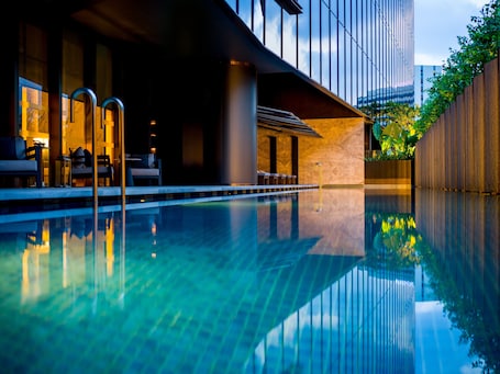 Una piscina al aire libre, sillones reclinables de piscina