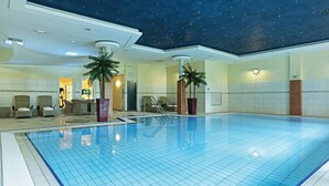 A large indoor swimming pool with a grid pattern, surrounded by lounge chairs and palm trees, and a ceiling with a starry design. - Fletcher Family Hotel Paterswolde (Paterswolde)