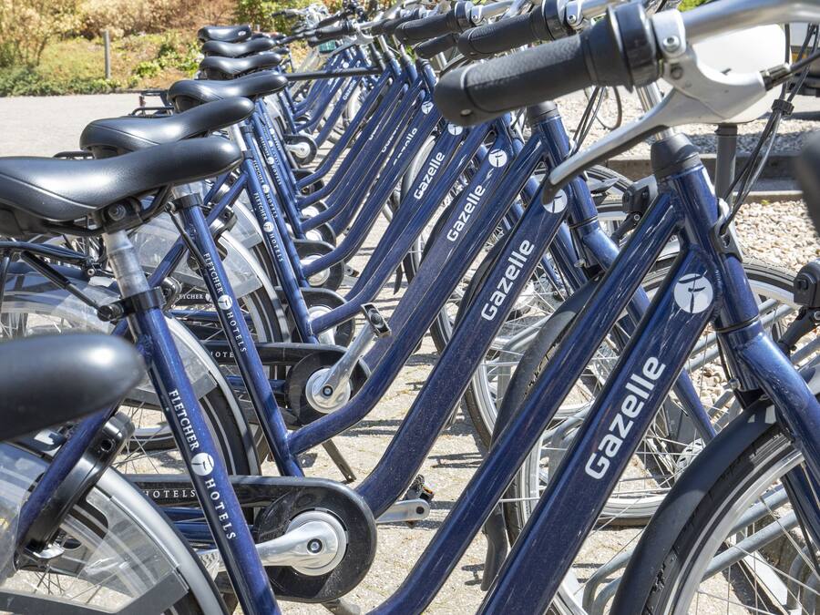 Een rij blauwe fietsen, merknaam 'Gazelle' zichtbaar op het frame.