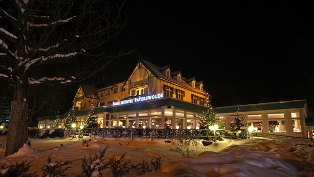 A hotel with a traditional architectural style, featuring a prominent entrance and a Christmas tree display. - Fletcher Family Hotel Paterswolde (Paterswolde)