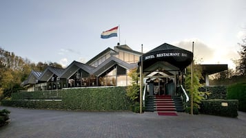 Experience the unique architectural design of this hotel, featuring a striking flagpole and beautifully manicured surroundings.