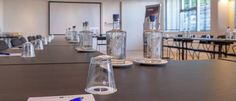 A conference room with a long table, water bottles, and a pen on a notepad.