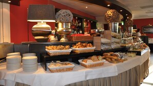 A buffet setup with various food items and a beverage station. - Fletcher Hotel-Restaurant Jan van Scorel (Schoorl)