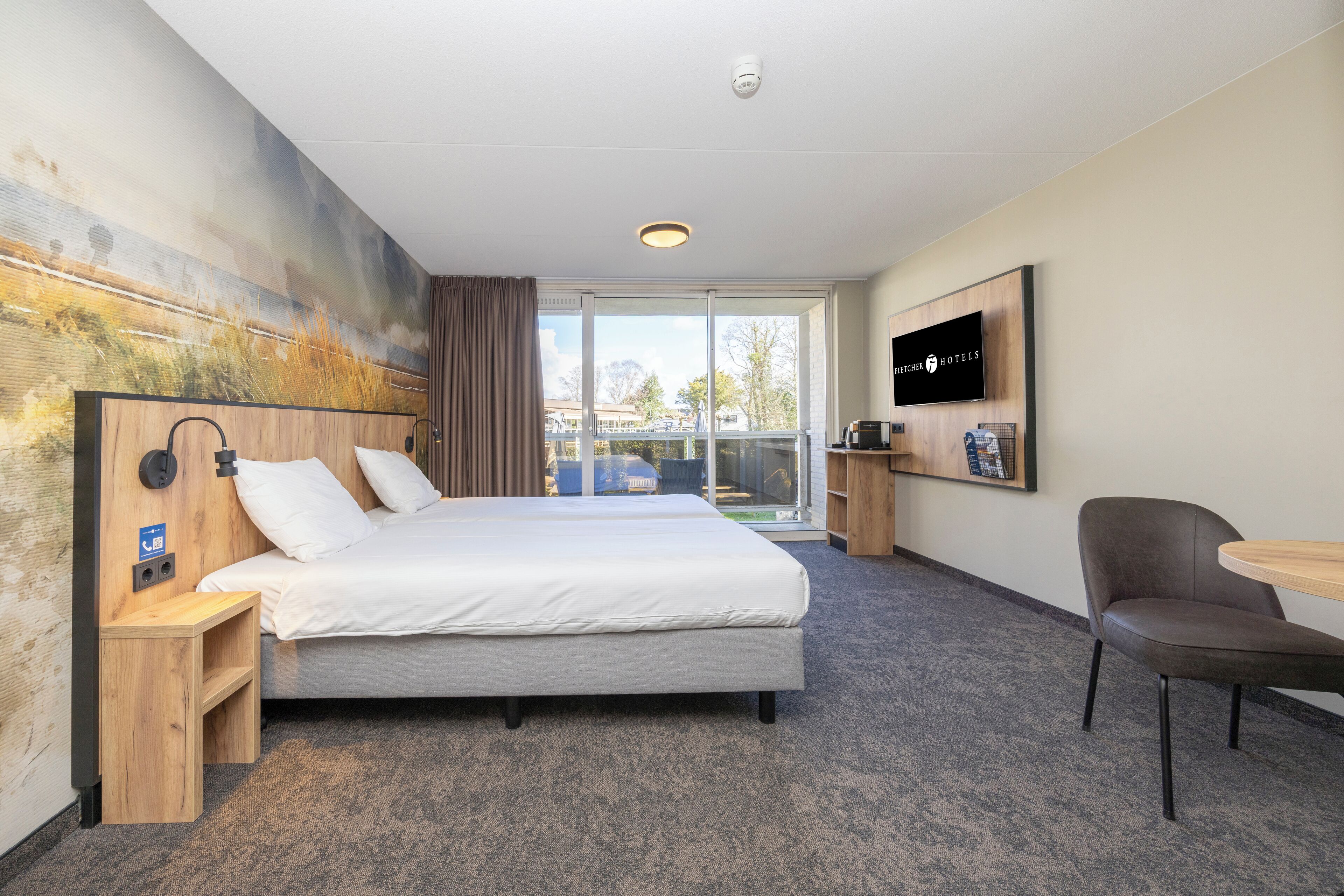 Une chambre d’hôtel avec un grand lit, une télévision, un bureau et une chaise.