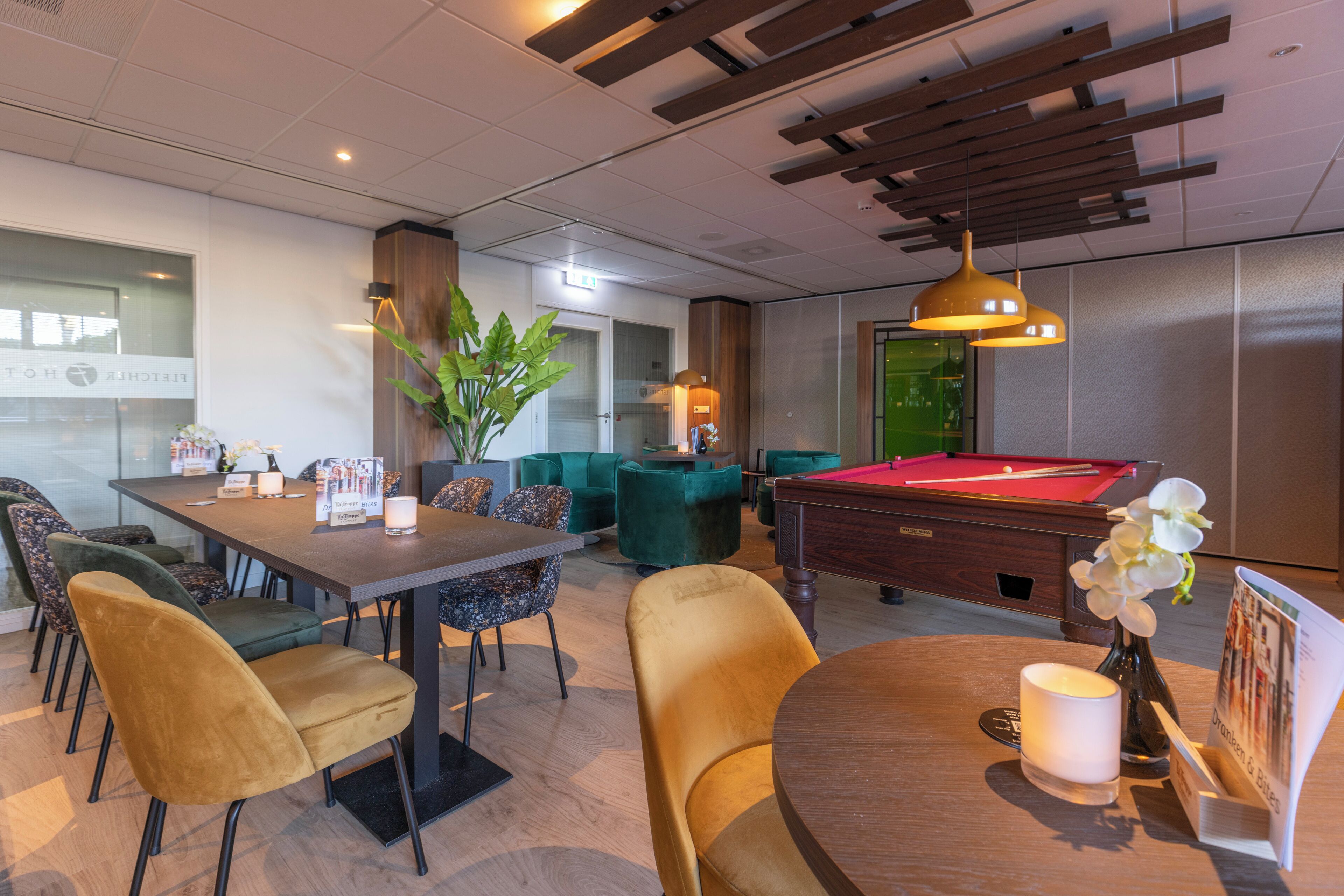 A modern lounge area with a pool table, comfortable seating, and a billiards table.