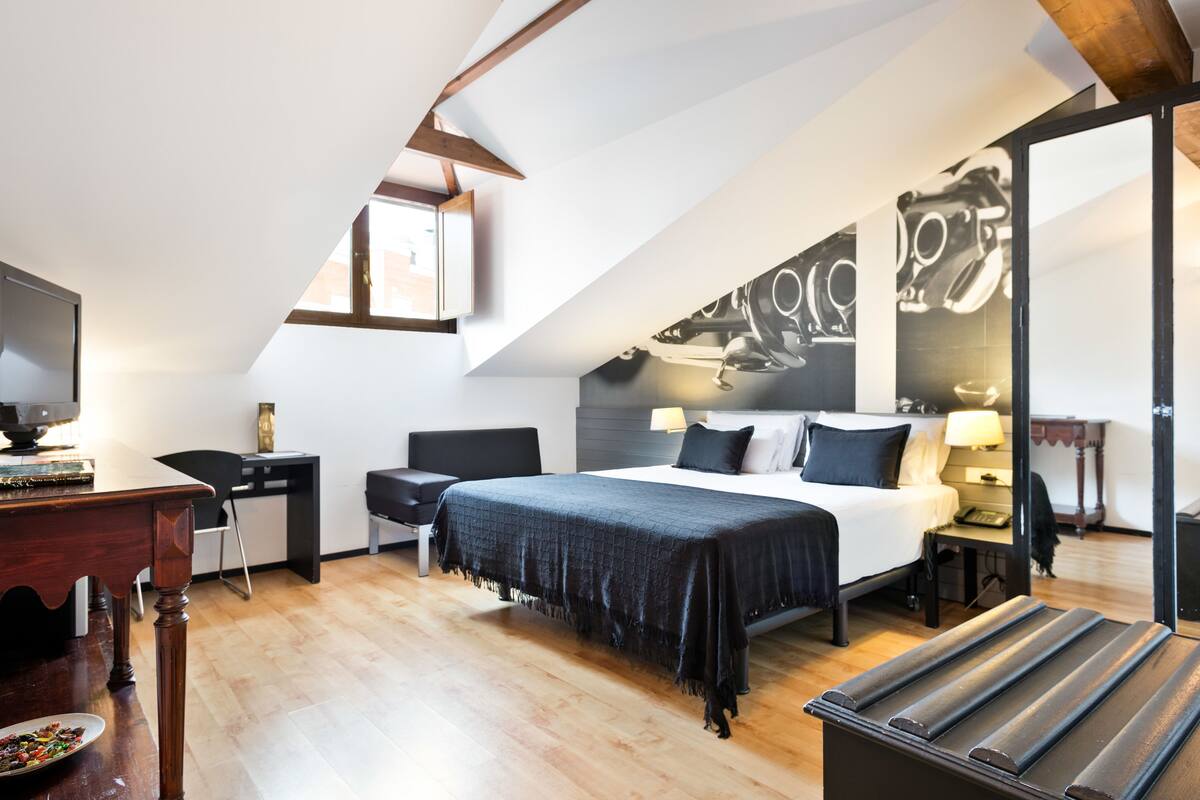 Een moderne hotelkamer met een groot bed, een bureau, een stoel en een eettafel.