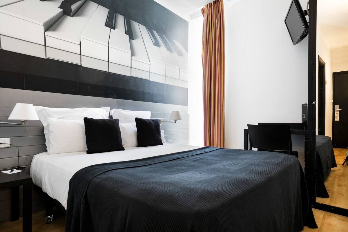 Een moderne hotelkamer met een groot bed, een bureau en een flatscreen-tv.