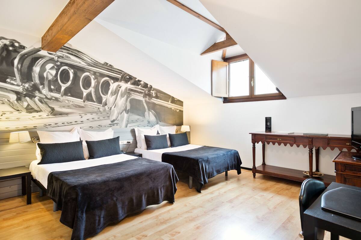 Een slaapkamer met twee bedden, een bureau en een grote muurschildering.