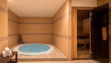 Relax in a serene spa area with a central hot tub, surrounded by a patterned tile border and a wooden bench.