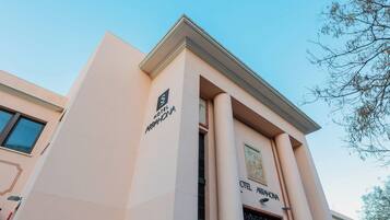 A hotel with a modern facade, featuring a prominent entrance with a large sign reading "HOTEL AGARHONA."