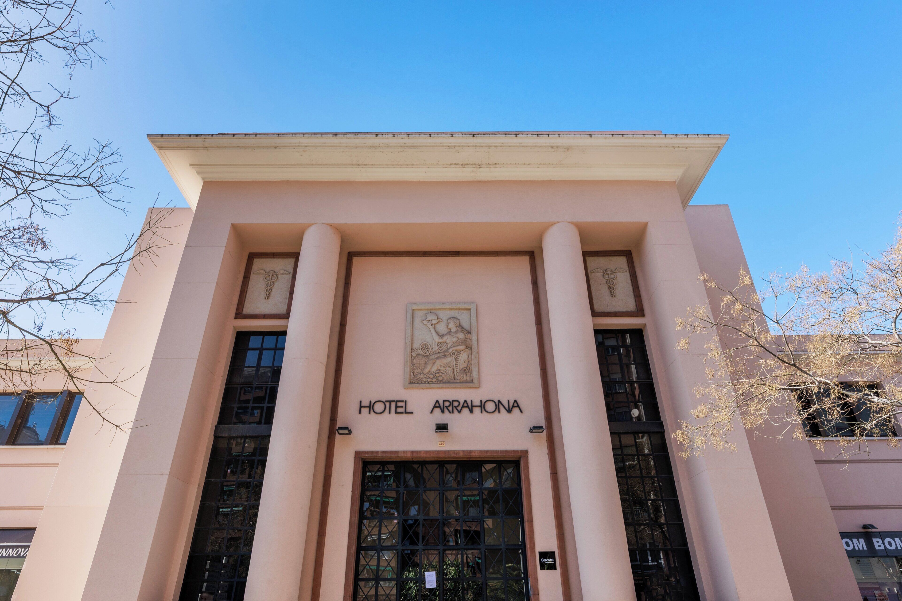 La façade de l’hôtel Arrahona présente un style architectural classique, avec une entrée centrale dotée d’une grande porte et de colonnes.