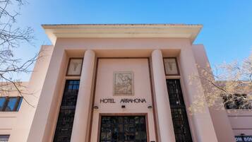 La façade de l’hôtel Arrahona présente un style architectural classique, avec une entrée centrale dotée d’une grande porte et de colonnes.