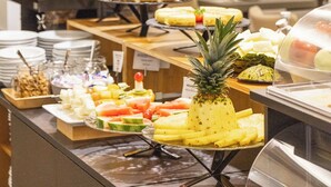 A buffet with various food items and a pineapple centerpiece. - Arc la Rambla (Barcelona)