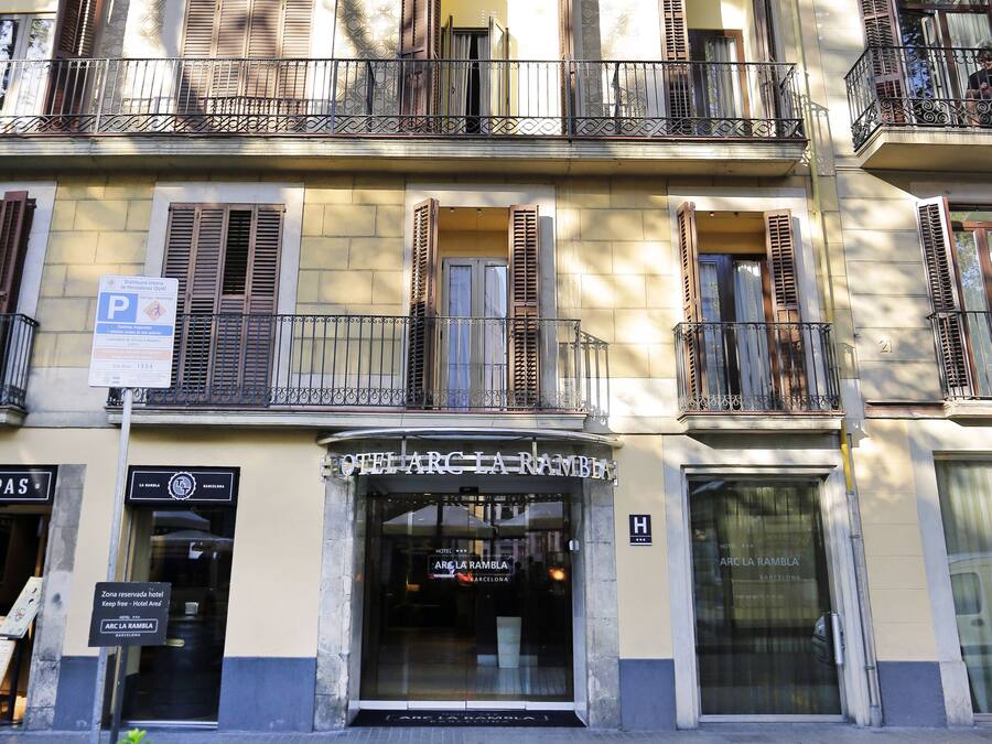 Entrada de hotel con un letrero que dice 'Hotel Arc La Rambla' y un letrero de 'P' para estacionamiento.