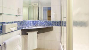 A bathroom with a glass shower enclosure, a sink with a towel rack, and a mirror. - Holiday Inn Express London-Royal Docks, Docklands by IHG (London)