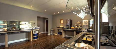 A modern kitchen with granite countertops, stainless steel appliances, and a glass partition.