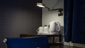 A room with a desk, a lamp, a coffee maker, and a chair. - Holiday Inn Express London-Royal Docks, Docklands by IHG (London)