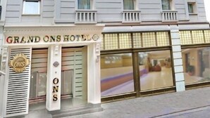 Um hotel de vários andares com fachada moderna, apresentando uma entrada imponente com a placa 