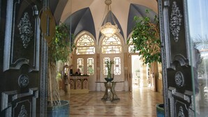 A grand lobby with ornate doors, a reception desk, and a chandelier. - Jacir Palace Hotel Bethlehem (Bethlehem)