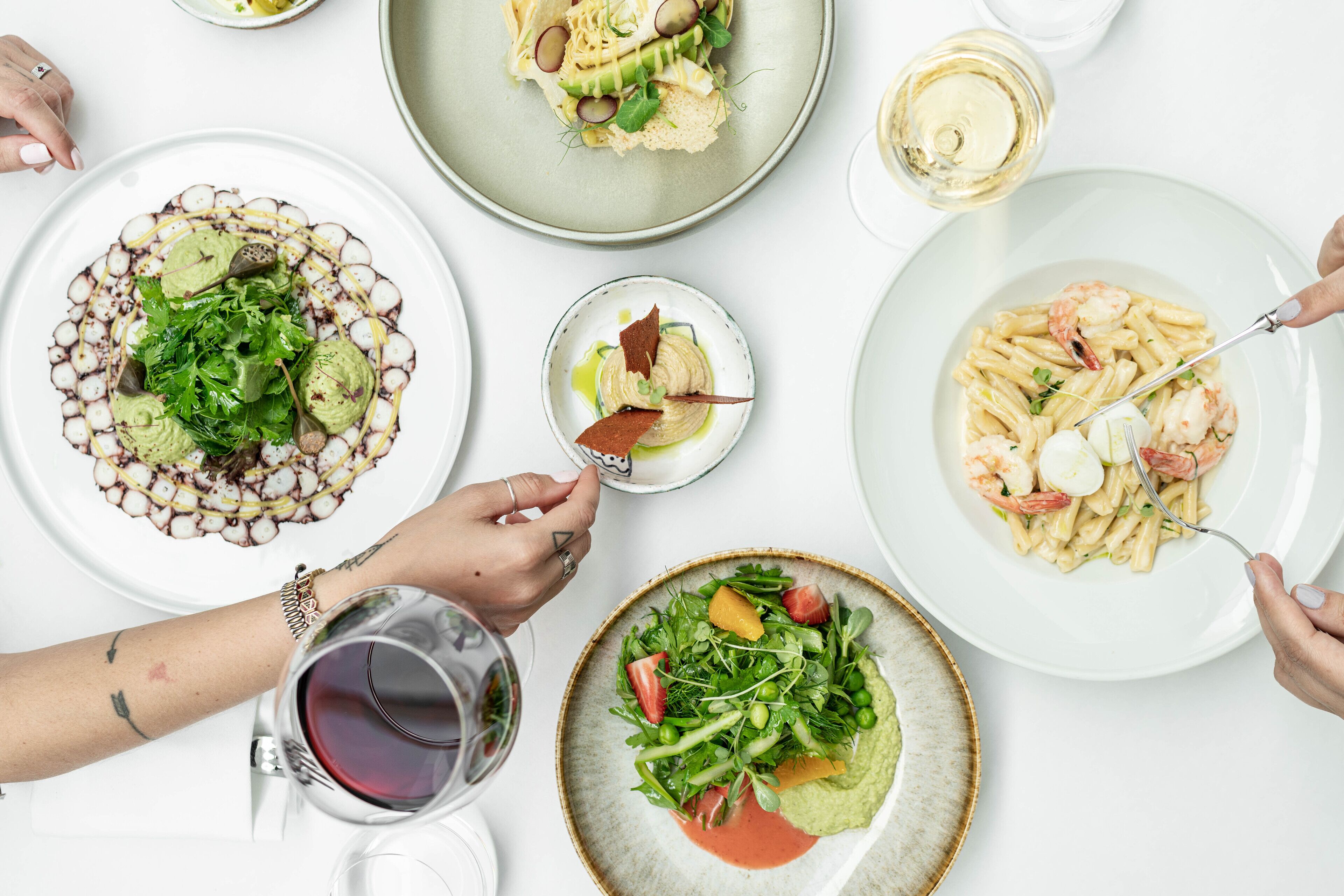 A dining table with various dishes and drinks.