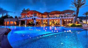 A luxurious hotel with a large swimming pool, stone architecture, and outdoor seating areas. - The Marmara Bodrum - Adult Only (Bodrum)