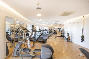 Un gimnasio con cintas de correr, elípticas y pesas.