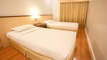 A hotel room with two beds, a nightstand, an air conditioning unit, and a curtain.