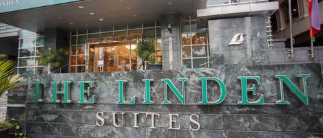 A hotel entrance with a sign reading "THE LINDEN SUITES".